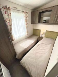 two beds in a small room with a window at The Rannoch Len 1 in Forfar