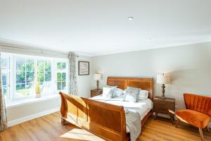 a bedroom with a bed and a chair and a window at Sparrowhawk Cottage with Hot Tub in Newton Stewart