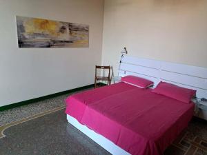 a bedroom with a large bed with pink sheets at Casa Gazzano in Imperia