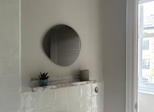 łazienka z lustrem na białej ścianie w obiekcie Strawberry Dale Apartment w mieście Harrogate