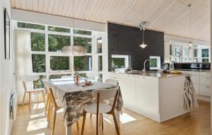 a kitchen and dining room with a table and chairs at Rubinsen Skovhuse in Hasle