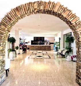 einen Torbogen, der in eine Lobby mit einem Kamin führt in der Unterkunft Sveltos Hotel in Larnaka