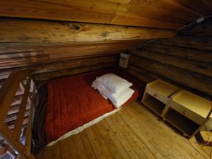 an attic room with a bed in a cabin at Lakeside wilderness cabin in Jokkmokk