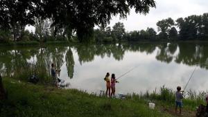 un grupo de personas pescando en un lago en Chata Uhelka en Uhelná
