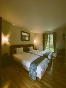 LamorlayeにあるHostellerie Du Lysのベッドルーム1室(ベッド2台、壁掛け鏡付)