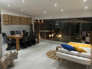ein Wohnzimmer mit einem Sofa, einem Tisch und Stühlen in der Unterkunft Chalet Privato con Jacuzzi New in Maspalomas