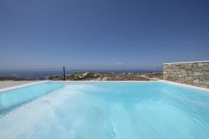 a large blue swimming pool with a view of the ocean at Villa Joy in Fanari