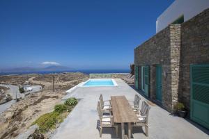 a house with a table and chairs next to a pool at Villa Joy in Fanari