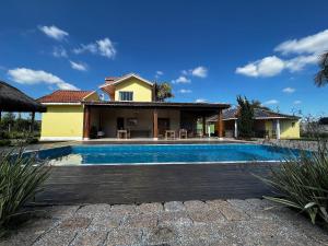 a villa with a swimming pool in front of a house at Pousada Ouro Verde in São Roque