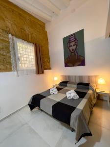 een slaapkamer met een zwart-wit bed en handdoeken bij Arte in piazza Agrigento centro in Agrigento