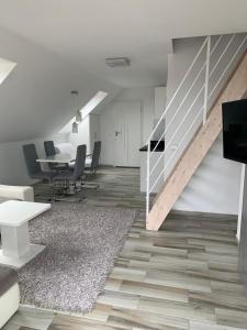 Habitación con escalera, mesa y sillas en Apartamenty i Pokoje Gracja Miedzyzdroje, en Międzyzdroje