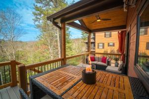 a screened in porch with a fire pit on a deck at Walk to Helen Downtown-Gated Golf Resort in Helen