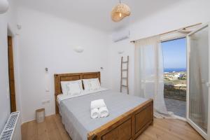 a bedroom with a bed and a large window at Villa Joy in Fanari