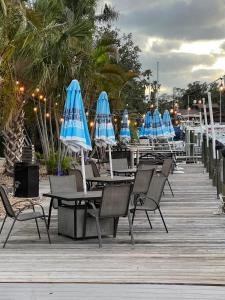 a group of tables and chairs with blue umbrellas at Marina Vibes - Sarasota in Sarasota