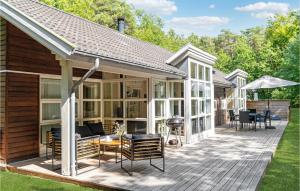 a screened in deck with furniture and an umbrella at Rubinsen Skovhuse in Hasle