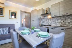 uma cozinha e sala de jantar com uma mesa de madeira e cadeiras em Relax House and Fitness 9 em Villanova Monteleone