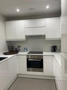 Merchiston Residence في إدنبرة: مطبخ ابيض مع دواليب بيضاء وموقد