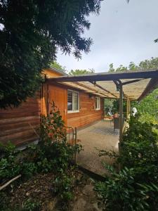 a wooden cabin with a pergola in front of it at Ferienhaus Portugieser auf dem Weinberg in Naumburg