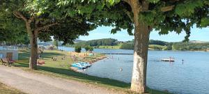 un groupe de personnes sur la rive d'un lac dans l'établissement maison piscine privée proche de Rodez, à Cassagnes-Bégonhès