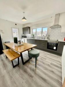 cocina con mesa de madera y taburete verde en Brewery Loft, en Newport