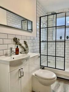 a white bathroom with a toilet and a sink at Brewery Loft in Newport