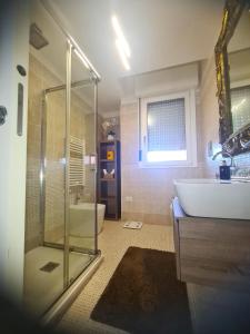 y baño con ducha, bañera y lavamanos. en Penthouse genneruxi en Cagliari