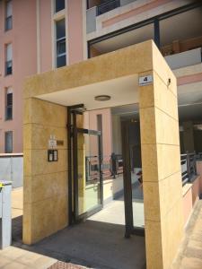 una entrada a un edificio con una puerta de cristal en Penthouse genneruxi en Cagliari