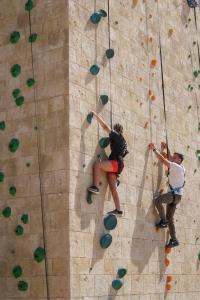 two people climbing on a rock wall at City of Dreams Mediterranean - Integrated Resort, Casino & Entertainment in Limassol