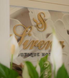 una señal para un hotel con flores delante en Sirena Boutique Hotel, en Gabicce Mare