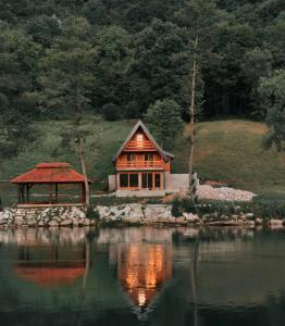a house sitting next to a body of water at Vikendica Krupa na Vrbasu in Banja Luka