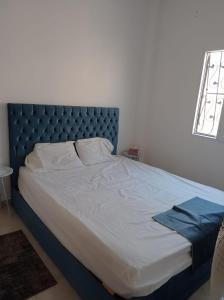 1 dormitorio con 1 cama con cabecero azul en 2 bedrooms private townhouse in Zayed en Sheikh Zayed