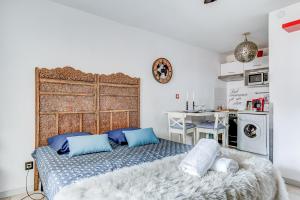 1 dormitorio con 1 cama grande con almohadas azules en L Oasis studio proche hôpital et aéroport Piscine Parking &Netflix, en Toulouse
