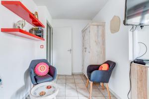 sala de estar con 2 sillas y mesa en L Oasis studio proche hôpital et aéroport Piscine Parking &Netflix, en Toulouse
