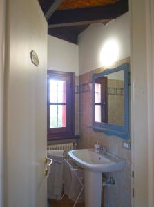 een badkamer met een wastafel, een toilet en een spiegel bij AC Ranch in Carentino