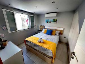 a bedroom with a bed with a yellow blanket and a window at Chalet Privato con Jacuzzi New in Maspalomas