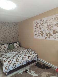 een slaapkamer met een bed en een schilderij aan de muur bij Honey rooms Hunedoara in Hunedoara
