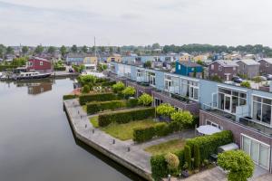 ariaal uitzicht op een huis met een tuin op het water bij Nautic Rentals - Marinapark Oude-Tonge in Oude-Tonge