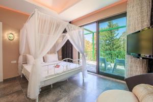 1 dormitorio con 1 cama blanca con dosel en KIDRAK PREMIUM VILLAS, en Fethiye