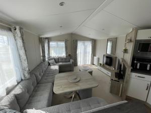 a living room with a couch and a table at Fairview Caravan Hire in Lossiemouth
