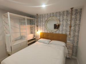 een slaapkamer met een wit bed en een spiegel bij Atractivo piso recién reformado in Santander