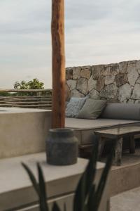 a couch sitting on top of a patio with a table at Teva Tulum, Aldea Zamá in Tulum