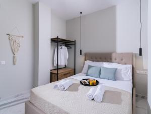 ein Bett mit Handtüchern und eine Obstschale darauf in der Unterkunft Arbona Apartment II in Vóroi