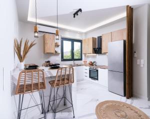 a kitchen with a white refrigerator and two bar stools at Arbona Apartment II in Vóroi