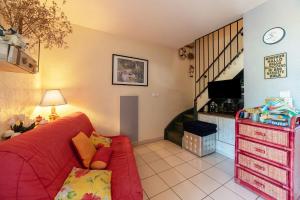 een woonkamer met een rode bank en een trap bij Marina in Le Barcarès