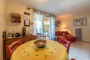 een eetkamer met een tafel en stoelen en een woonkamer bij Marina in Le Barcarès