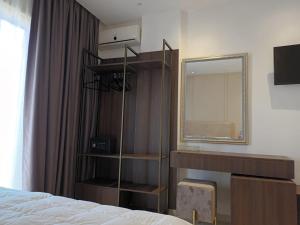 1 dormitorio con espejo, estante y cama en Hotel Relax Dhermi en Dhërmi