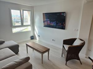 a living room with a couch and a chair and a table at Atractivo piso recién reformado in Santander