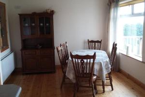 a dining room with a table and chairs and a window at Three Sisters Holiday Home - 7km to Dingle in Ballyferriter