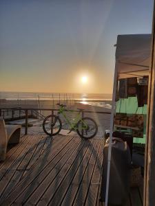 a bike is parked on a boardwalk at the beach at Grandma villa in Pataias