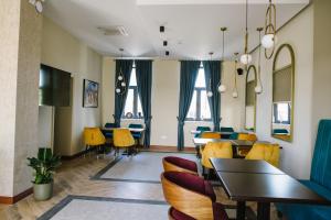 a dining room with tables and chairs and windows at AVIOR Garni Hotel in Subotica